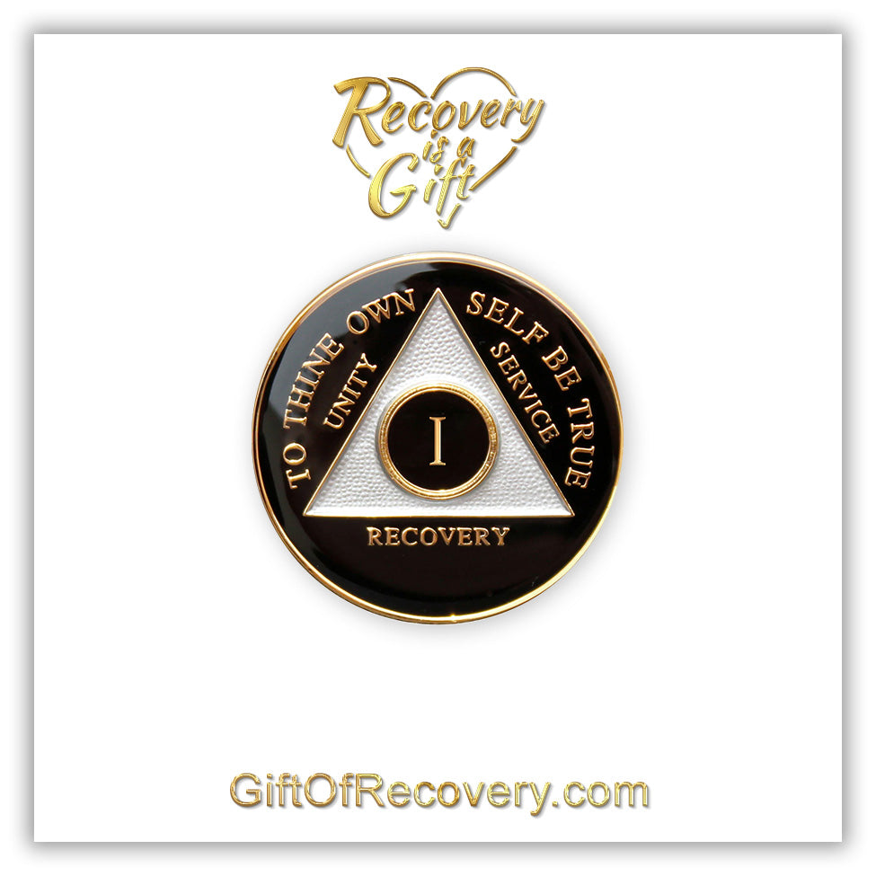 1 year AA medallion black Onyx, triangle is pearl white, to thine own self be true, unity, service, recovery, and roman numeral are embossed with 14k gold-plated brass, the recovery medallion is sealed with resin for a glossy finish that will last and is scratch free, pictured on a white 3x3 card with recovery is a gift going through an open heart at the top and giftofrecovery.com on the bottom, both in the color gold.