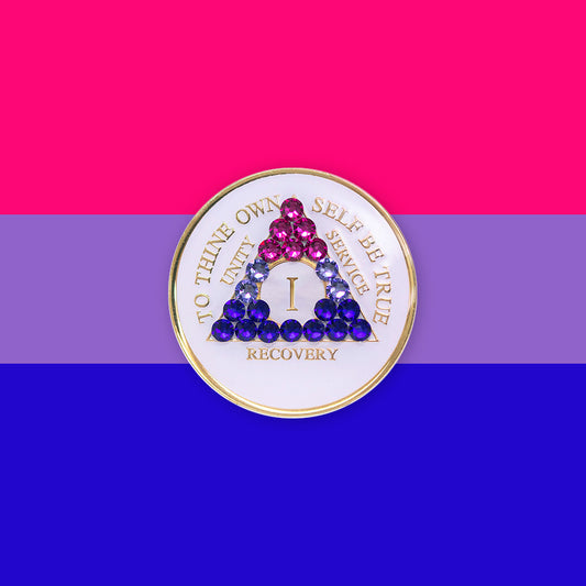 1 year AA medallion pearl white with 21 genuine crystals that form the triangle and are in the color of the bisexual flag, to represent pride and sobriety, the AA slogan and three legacies are embossed with 14k gold-plated brass and sealed with resin for a glossy finish that will last and is scratch proof, pictured on an image of the Bisexual flag colors.