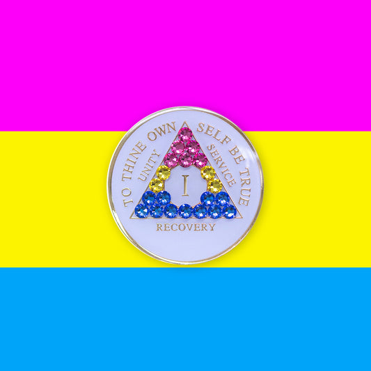 1 year AA medallion pearl white with 21 genuine crystals that form the triangle and are in the color of the Pansexual flag, to represent pride and sobriety, the AA slogan and three legacies are embossed with 14k gold-plated brass and sealed with resin for a glossy finish that will last and is scratch proof, pictured on an image of the Pansexual flag colors.