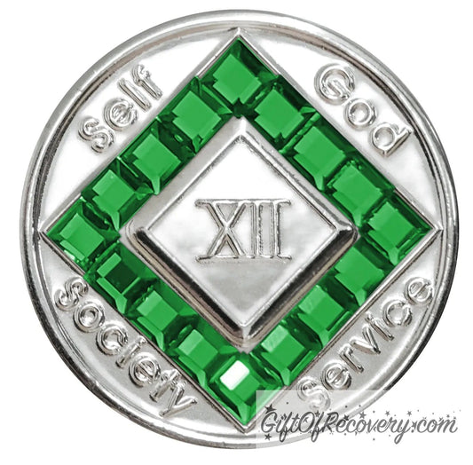 12 year nickel plated NA medallion with self, God, Society, and Service around the outer rim of the diamond, 16 square Emerald CZ genuine crystals that form the diamond around the roman numeral.