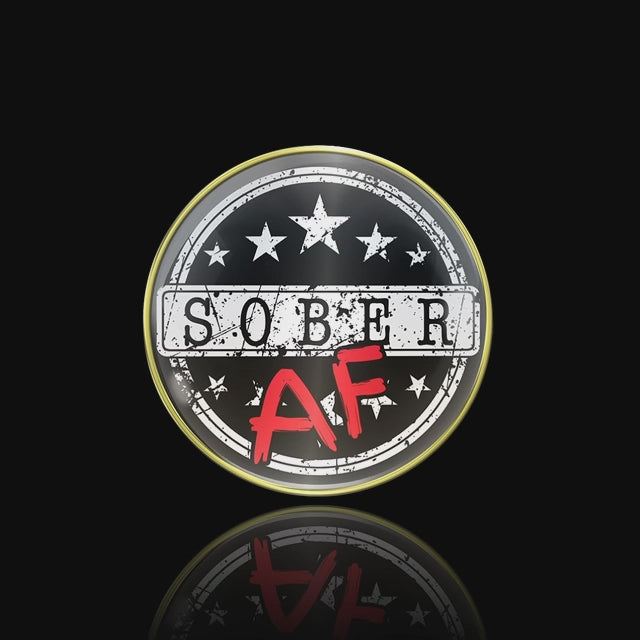 Sober AF AA medallion with sober in black on a white rectangle strip, and the AF in bold red, there are 10 white stars, 5 above sober and 5 below, there are 2 white circles near the 14k rim for outline, set in a black screen revolving to show an accurate depiction on the recovery medallion.