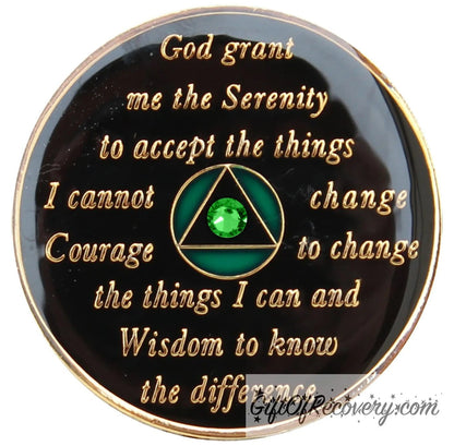 Back of AA Medallion emerald green, recovery medallion is black and has the raised serenity prayer, outer rim, and the circle triangle in the center in 14k gold, inside the black triangle is 1 green genuine crystal, with emerald green accents in the circle.