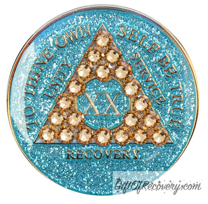 20 year Aqua glitter AA medallion with 21 gold genuine crystal making a triangle in the center, and to thine own self be true, unity, service, recovery, the roman numeral in the center and the rim of the recovery medallion embossed in 14k gold plated brass and sealed with resin for a glossy shine.