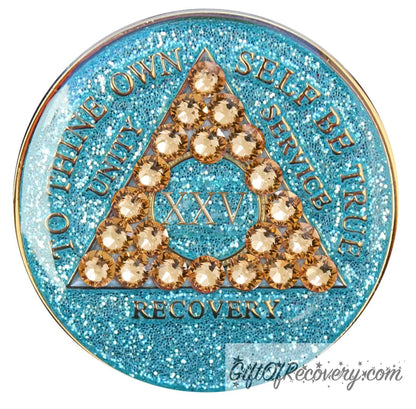 25 year Aqua glitter AA medallion with 21 gold genuine crystal making a triangle in the center, and to thine own self be true, unity, service, recovery, the roman numeral in the center and the rim of the recovery medallion embossed in 14k gold plated brass and sealed with resin for a glossy shine.