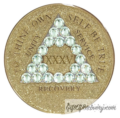 35 year AA medallion in gold glitter with twenty-one genuine diamond CZ crystals in the shape of a triangle, symbolizing transformation under pressure, to thine own self be true, unity, service, recovery and roman numeral are embossed with 14k gold-plated brass along with outer rim, sealed in a chip and scratch-resistant resin giving it a beautiful glossy look.