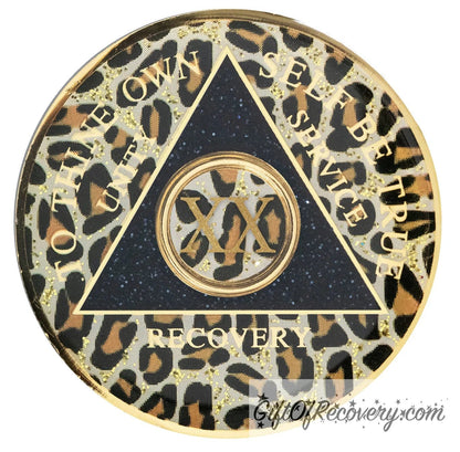 20 year AA medallion leopard print with gold flaked spots, to thine own self be true, unity, service, recovery, and roman numeral are gold foil so you can let your recovery shine, not your time, the circle triangle is embossed with 14k gold-plated brass, the recovery medallion is sealed with resin for a shiny finish.