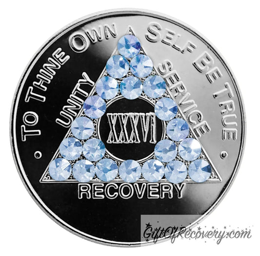 36 year aluminum AA recovery medallion with 21 light blue genuine crystals for the triangle along with the AA slogan and three legacies.