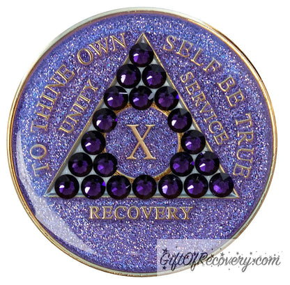 10 year glitter purple AA medallion with 21 purple velvet genuine crystals, that create the triangle in middle, and to thine own self be true, unity, service, recovery, the roman numeral in the center of the circle triangle, along with the rim of the recovery medallion, are embossed in 14 gold plated brass, sealed in resin for glossy finish.