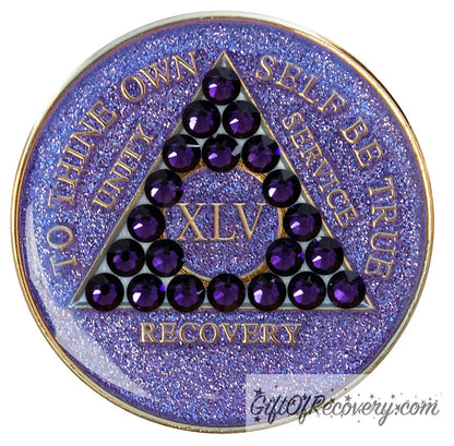 45 year glitter purple AA medallion with 21 purple velvet genuine crystals, that create the triangle in middle, and to thine own self be true, unity, service, recovery, the roman numeral in the center of the circle triangle, along with the rim of the recovery medallion, are embossed in 14 gold plated brass, sealed in resin for glossy finish.
