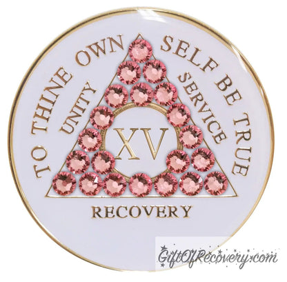 15 year pearl white AA medallion with Twenty-one genuine rose crystals in the shape of the triangle, unity, service, recovery, roman numeral, and to thine own self be true, embossed in 14k gold-plated brass and sealed with resin for a glossy finish that is scratch proof and will last.