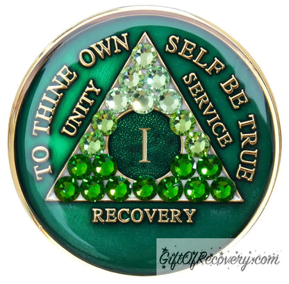 1 year AA medallion, emerald green with 21 genuine green crystals ranging from light to dark green in the shape of the triangle in the center to emphasize the transformation in the recovery journey, to thine own self be true, roman number, unity, service recovery are embossed in 14k gold-plated brass, the middle circle is sparkle green and the recovery medallion is sealed in resin for a shiny finish that lasts.