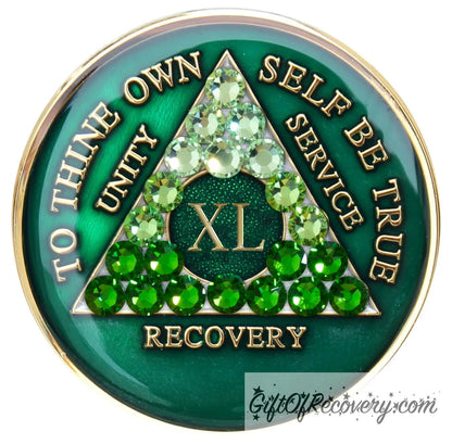 40 year AA medallion, emerald green with 21 genuine green crystals ranging from light to dark green in the shape of the triangle in the center to emphasize the transformation in the recovery journey, to thine own self be true, roman number, unity, service recovery are embossed in 14k gold-plated brass, the middle circle is sparkle green and the recovery medallion is sealed in resin for a shiny finish that lasts.
