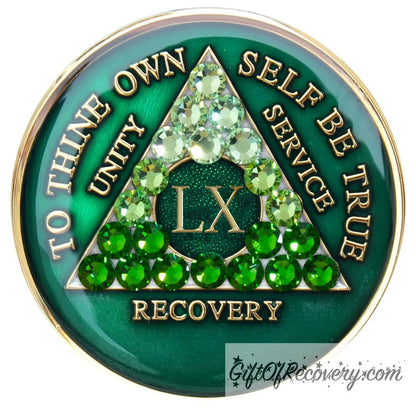 60 year AA medallion, emerald green with 21 genuine green crystals ranging from light to dark green in the shape of the triangle in the center to emphasize the transformation in the recovery journey, to thine own self be true, roman number, unity, service recovery are embossed in 14k gold-plated brass, the middle circle is sparkle green and the recovery medallion is sealed in resin for a shiny finish that lasts.