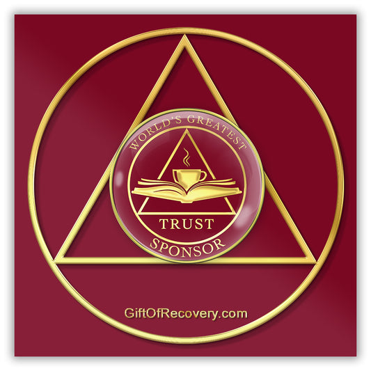 AA medallion Ruby red with a triangle, and open book with a coffee cup overlapping with the word trust at the bottom, worlds greatest at the top of the medallion and sponsor at the bottom, sealed with resin for a glossy finish, featured on a red 3x3 card that is a replica of the recovery medallion.
