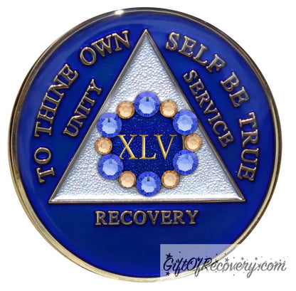 45 year AA medallion Big Book blue with 6 genuine blue crystals and 6 gold in a circle around the roman numeral like a flower symbolizing the 12 steps and growth in recovery, the triangle is pearl white, AA slogan and three legacies are embossed 14k gold-plated brass, sealed with resin for a shiny finish.