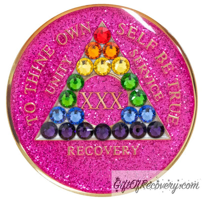 30 year AA medallion pink glitter princess with 21 genuine crystals in the colors of the rainbow to represent the LBGTQIA+ community or renewal and self-discovery in your recovery journey, in the shape of the triangle, the AA moto is embossed with 14k gold-plated brass and sealed with resin for a shiny finish.