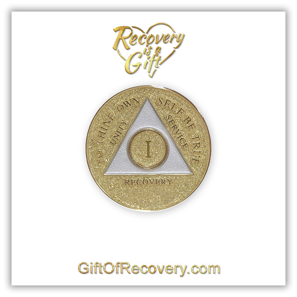 1 year AA medallion Gold glitter, with the triangle pearl white and to thine own self be true, unity, service, recovery, and the roman numeral embossed with 14k gold-plated brass, the recovery medallion is sealed with resin for a shiny finish that will last and is scratch proof, the medallion is featured on a white 3x3 card with recovery is a gift going through a heart in the center top and giftofrecovery.com at the bottom center, both are in the color gold. 